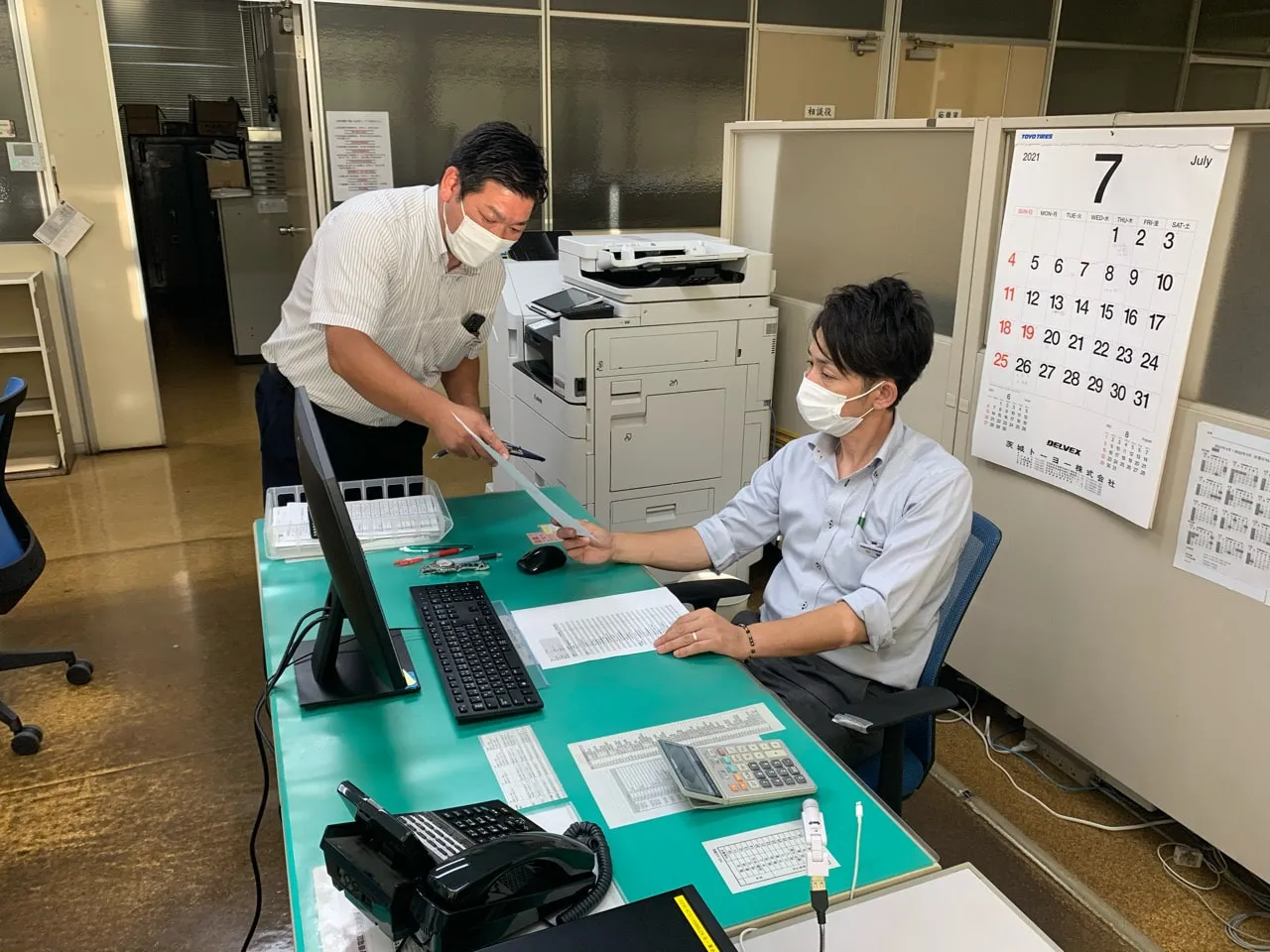 事務所で打ち合わせをする社員