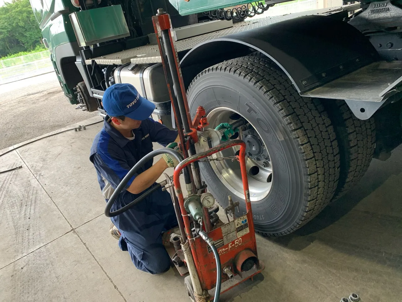 大型トラックのタイヤを交換する社員
