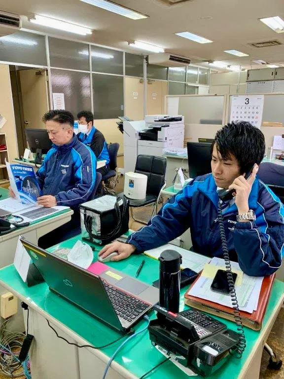 事務所で電話を受ける社員